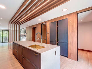 This modern kitchen features a sleek island with a built-in gold sink and a black faucet, perfect for cooking and entertaining.