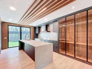 This contemporary kitchen boasts a spacious island with a unique marble countertop, providing ample space for food preparation and casual dining.