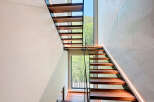 This modern home features a striking staircase design with open wooden treads and glass railings, creating a light and airy feel.