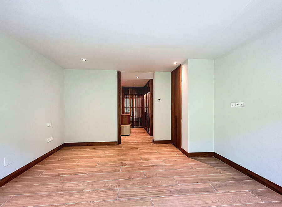 This is a bright and airy room with beautiful wood flooring and natural light.
