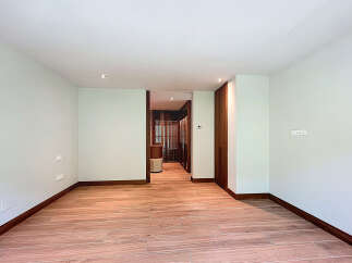 This is a bright and airy room with beautiful wood flooring and natural light.