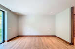 This empty room features beautiful wood-look tile flooring and a clean, minimalist aesthetic.