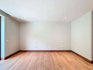 This empty room features beautiful wood-look tile flooring and a clean, minimalist aesthetic.