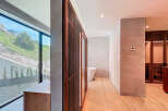 This bathroom features a large window with scenic views, wood-look tile flooring, and a modern vanity.