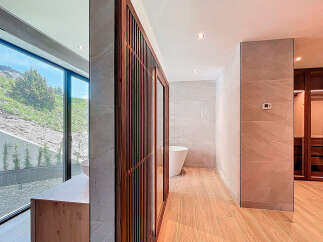 This bathroom features a large window with scenic views, wood-look tile flooring, and a modern vanity.