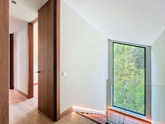 This property boasts natural light through its expansive window, complemented by warm wooden accents and modern lighting.