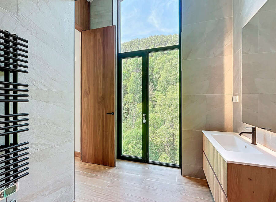 This luxurious bathroom features a modern vanity with a sleek countertop and a contemporary faucet.