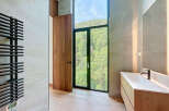 This luxurious bathroom features a modern vanity with a sleek countertop and a contemporary faucet.