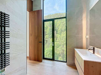 This luxurious bathroom features a modern vanity with a sleek countertop and a contemporary faucet.