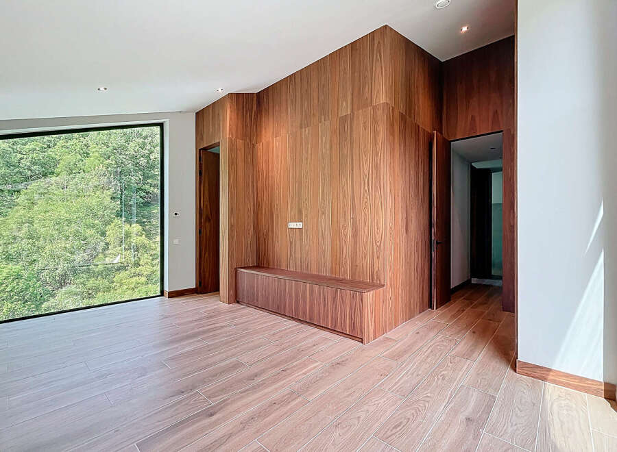 This modern living space features stunning wood paneling and flooring, creating a warm and inviting atmosphere.