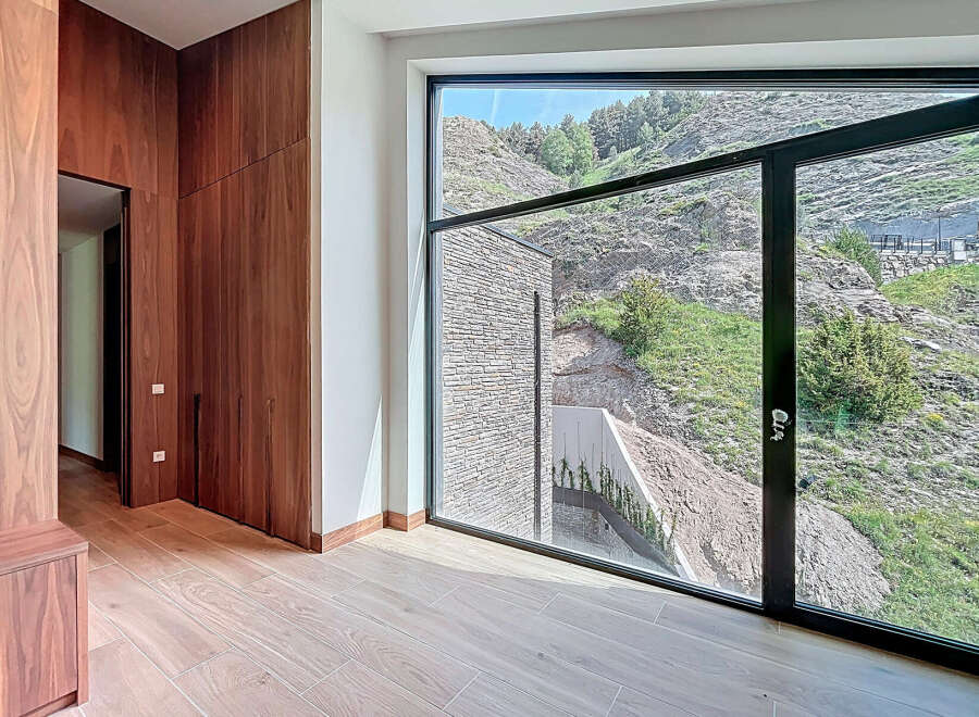 Luxury home interior showcasing sleek wooden cabinetry and light wood flooring.