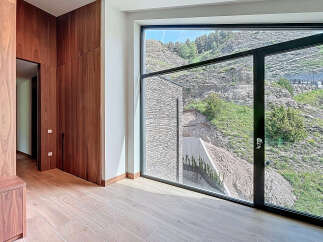 Luxury home interior showcasing sleek wooden cabinetry and light wood flooring.