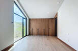 This modern bedroom boasts a wall of sleek, wooden built-in wardrobes, offering ample storage space.