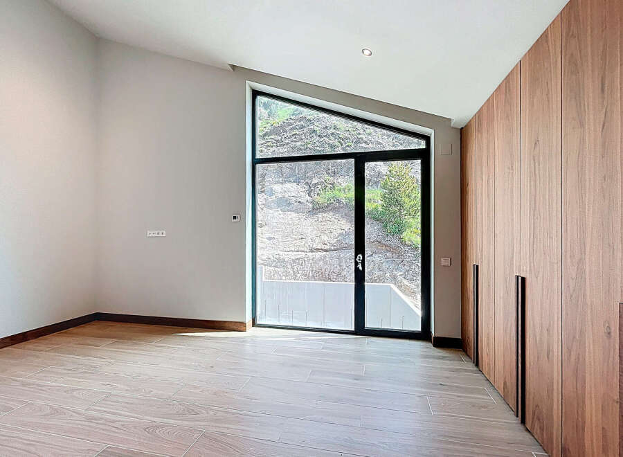 This room boasts a unique architectural window offering natural light and views of the outdoors.