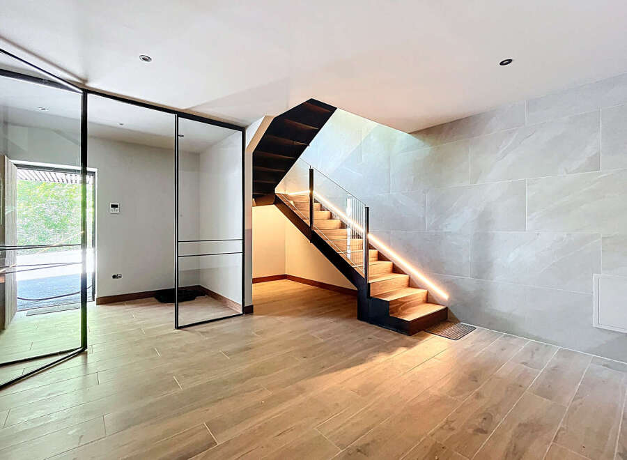 This modern home features a stunning staircase with integrated LED lighting, creating a warm and inviting ambiance.