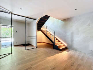 This modern home features a stunning staircase with integrated LED lighting, creating a warm and inviting ambiance.