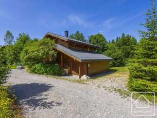 Discover this charming mountain chalet nestled among lush greenery, offering a serene retreat.