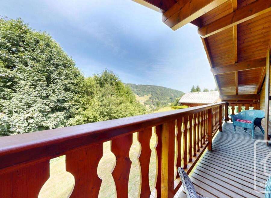 Enjoy the stunning views from the wooden balcony of this charming chalet.