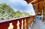 Enjoy the stunning views from the wooden balcony of this charming chalet.