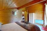 Escape to this cozy chalet bedroom featuring warm wood paneling on the walls and ceiling, creating an inviting, rustic ambiance.