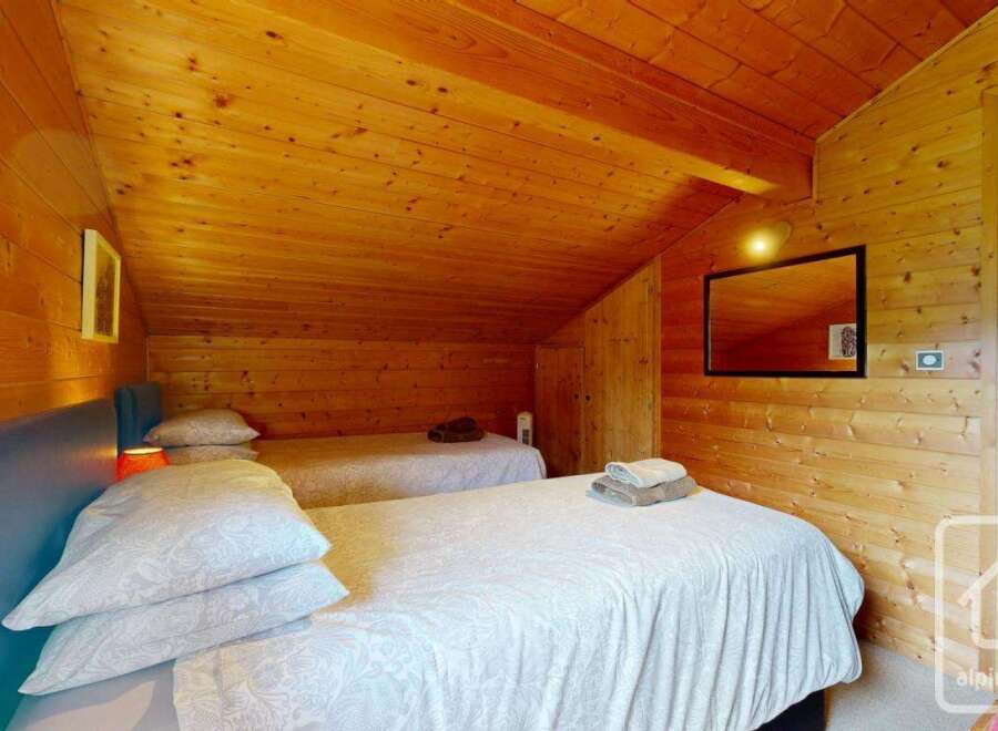 This inviting bedroom features twin beds with cozy white linens, perfect for a relaxing stay.