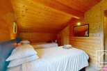 This inviting bedroom features twin beds with cozy white linens, perfect for a relaxing stay.
