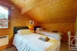 This charming bedroom features warm, wood-paneled walls and ceiling, creating a cozy, rustic atmosphere.