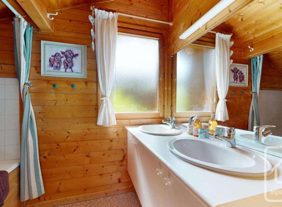 This charming bathroom features warm wood paneling on the walls and ceiling, creating a cozy and rustic atmosphere.
