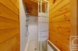 This bathroom showcases a sleek shower stall with sliding doors, complemented by wood-paneled walls that add warmth and character.