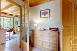 Discover a charming chalet hallway featuring wooden accents, including a dresser and doors that add warmth and character.