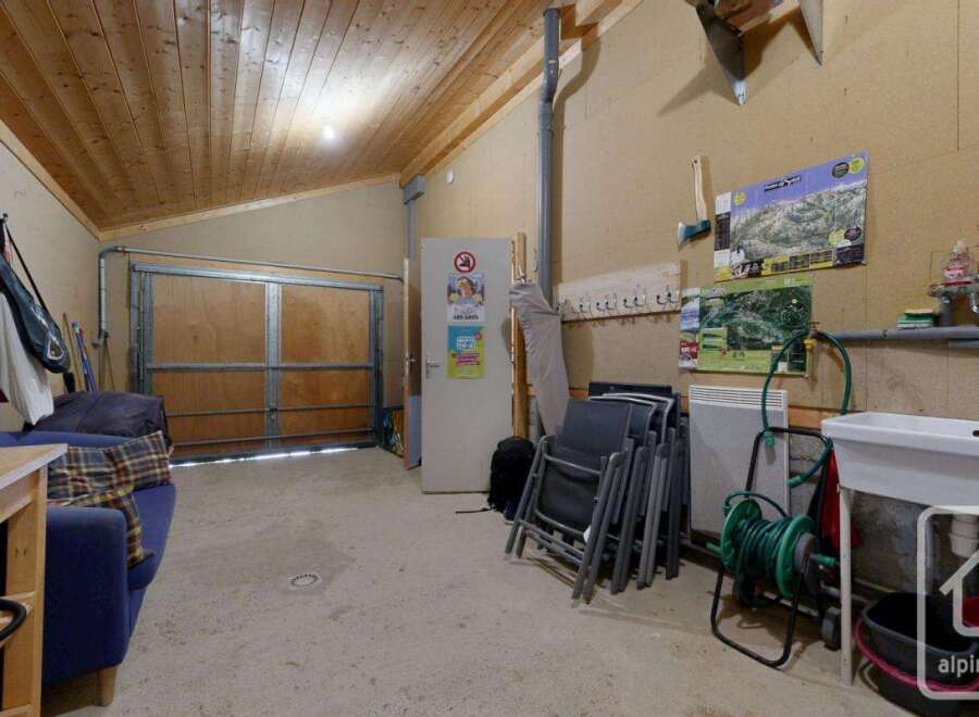 This property features a versatile garage space with a wooden ceiling and ample storage.