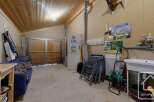 This property features a versatile garage space with a wooden ceiling and ample storage.