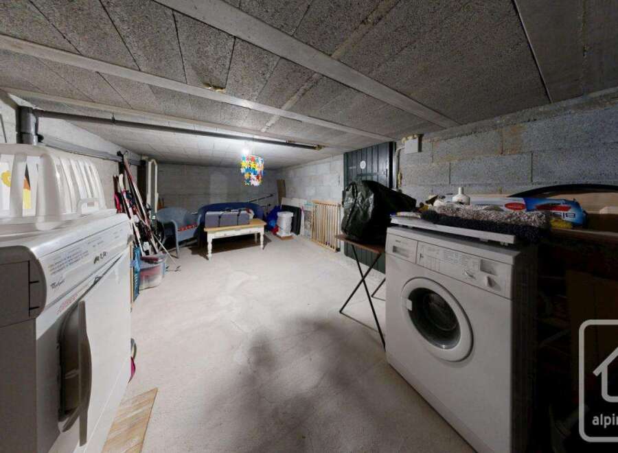 This is a functional basement laundry area with a washing machine.