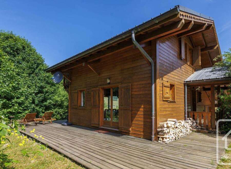 Discover this charming wooden chalet featuring a spacious deck perfect for relaxation and enjoying the outdoors.