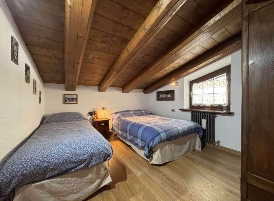 This charming bedroom features exposed wooden beams that create a rustic ambiance.