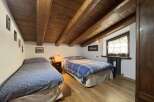 This charming bedroom features exposed wooden beams that create a rustic ambiance.