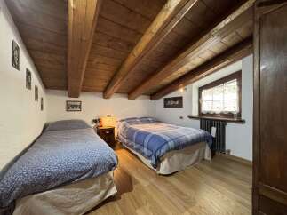 This charming bedroom features exposed wooden beams that create a rustic ambiance.
