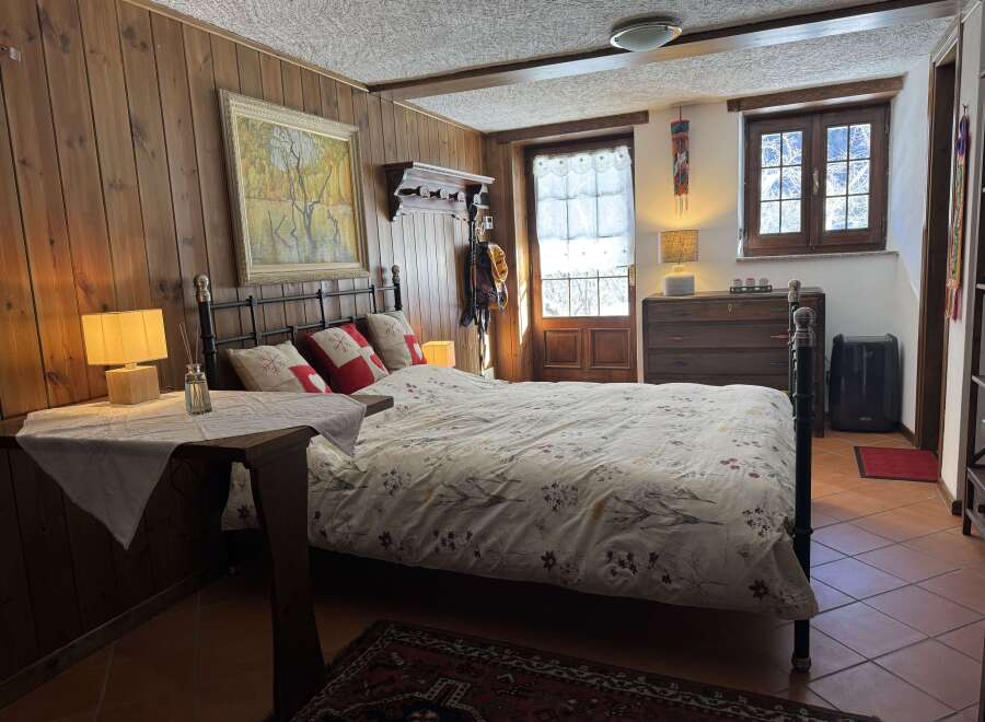 A cozy bedroom boasts charming wood-paneled walls and a comfortable bed, perfect for a relaxing retreat.