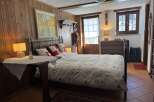 A cozy bedroom boasts charming wood-paneled walls and a comfortable bed, perfect for a relaxing retreat.