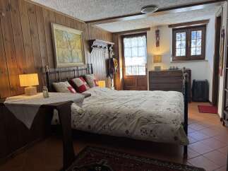 A cozy bedroom boasts charming wood-paneled walls and a comfortable bed, perfect for a relaxing retreat.