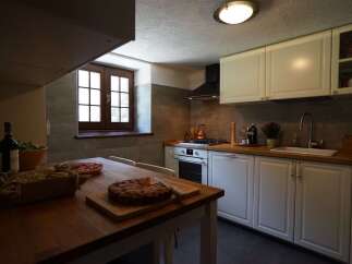This charming kitchen features warm wood countertops, white cabinets, and a classic window.