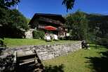Escape to this charming Swiss chalet nestled in the mountains, boasting a stone facade and multiple balconies.