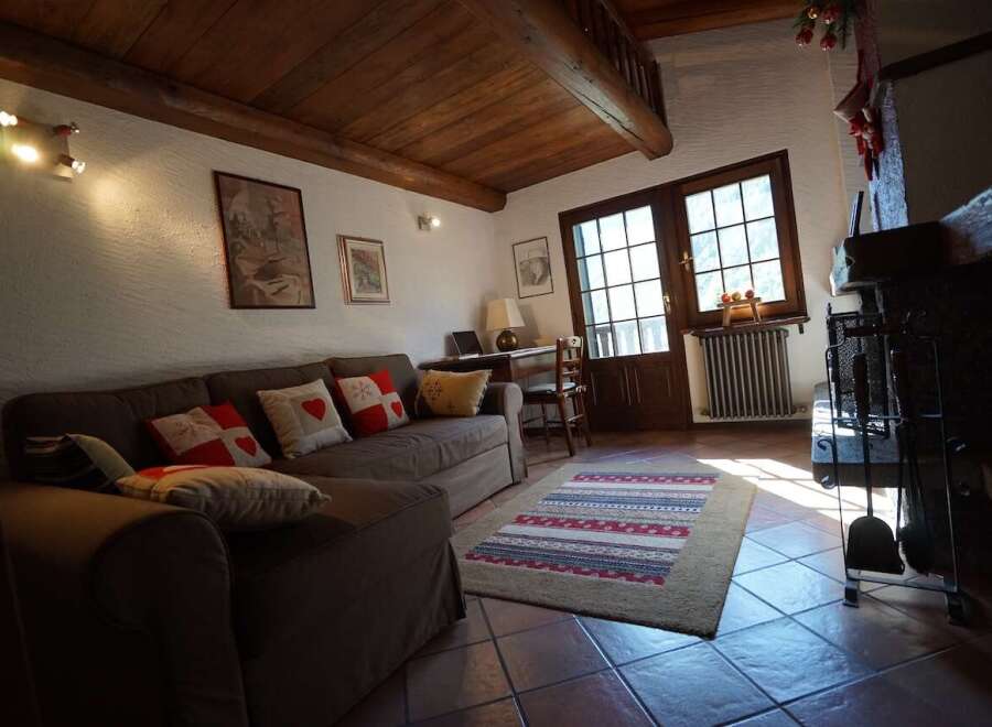 This charming living room features a cozy sofa adorned with decorative pillows, perfect for relaxing by the fireplace.