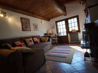 This charming living room features a cozy sofa adorned with decorative pillows, perfect for relaxing by the fireplace.