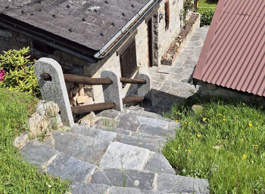 Discover the charm of this stone house, nestled amidst lush greenery and accessible via rustic stone steps.