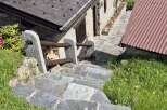 Discover the charm of this stone house, nestled amidst lush greenery and accessible via rustic stone steps.