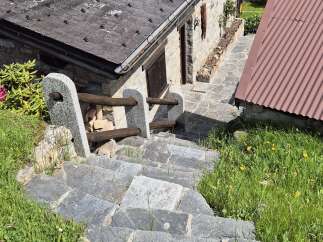 Discover the charm of this stone house, nestled amidst lush greenery and accessible via rustic stone steps.