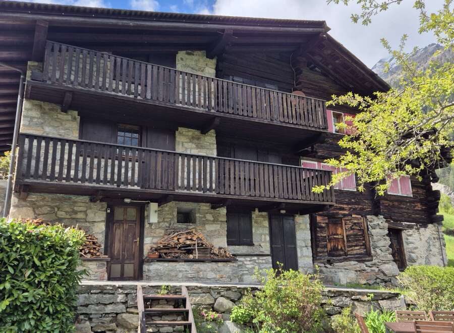 Discover this charming multi-story home featuring rustic stone and wood construction, complete with inviting balconies.