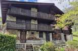 Discover this charming multi-story home featuring rustic stone and wood construction, complete with inviting balconies.