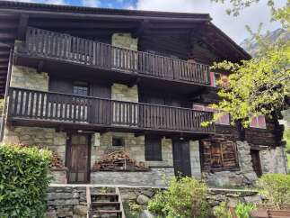 Discover this charming multi-story home featuring rustic stone and wood construction, complete with inviting balconies.